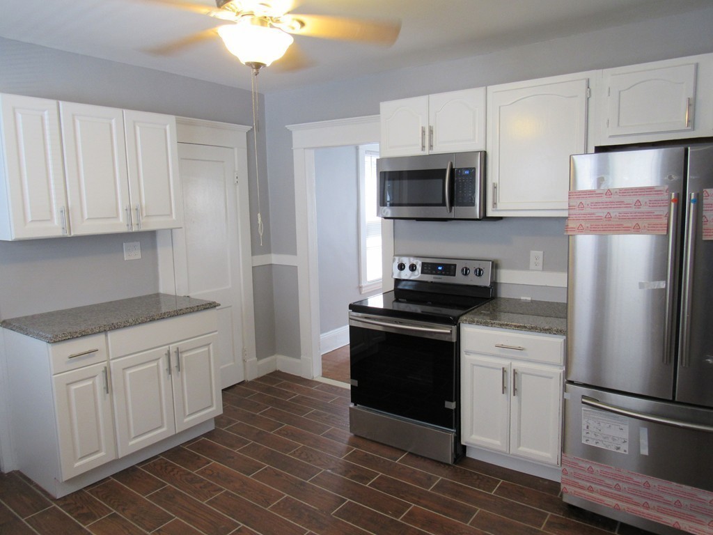 55 Rimmon Avenue Springfield, MA 01107 - Photo 2 of 17 a kitchen with granite countertop a refrigerator stove and white cabinets