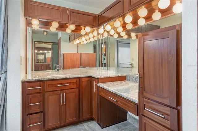 a bathroom with a granite countertop sink and a mirror