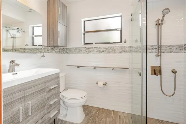 a bathroom with a granite countertop toilet sink and mirror