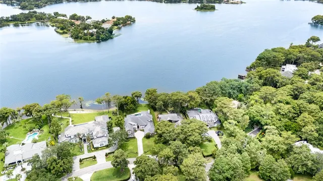 an aerial view of a house with a yard and lake view