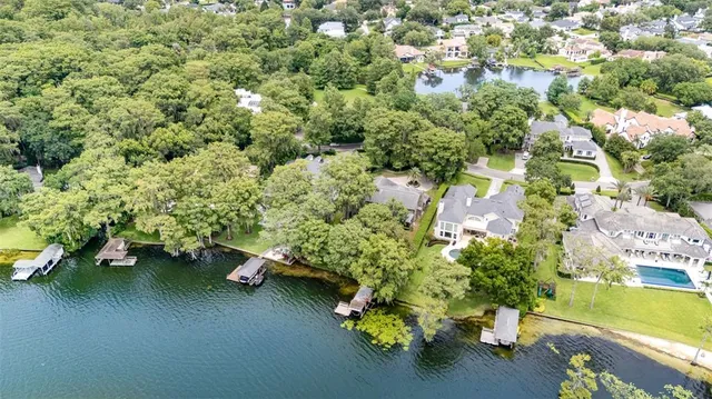 an aerial view of a house with a yard swimming pool and outdoor seating