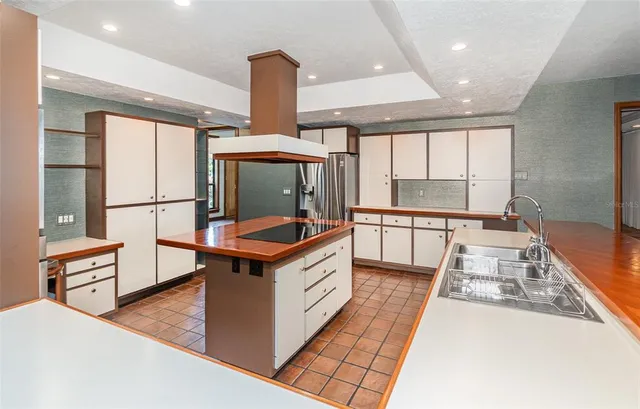 a kitchen with stainless steel appliances granite countertop a stove a sink and a refrigerator