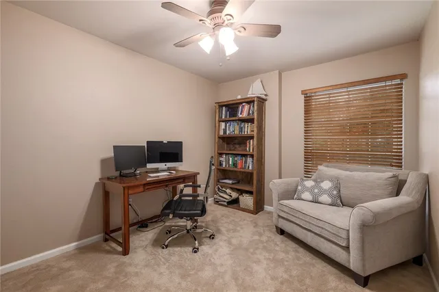 a view of a livingroom with workspace and a window