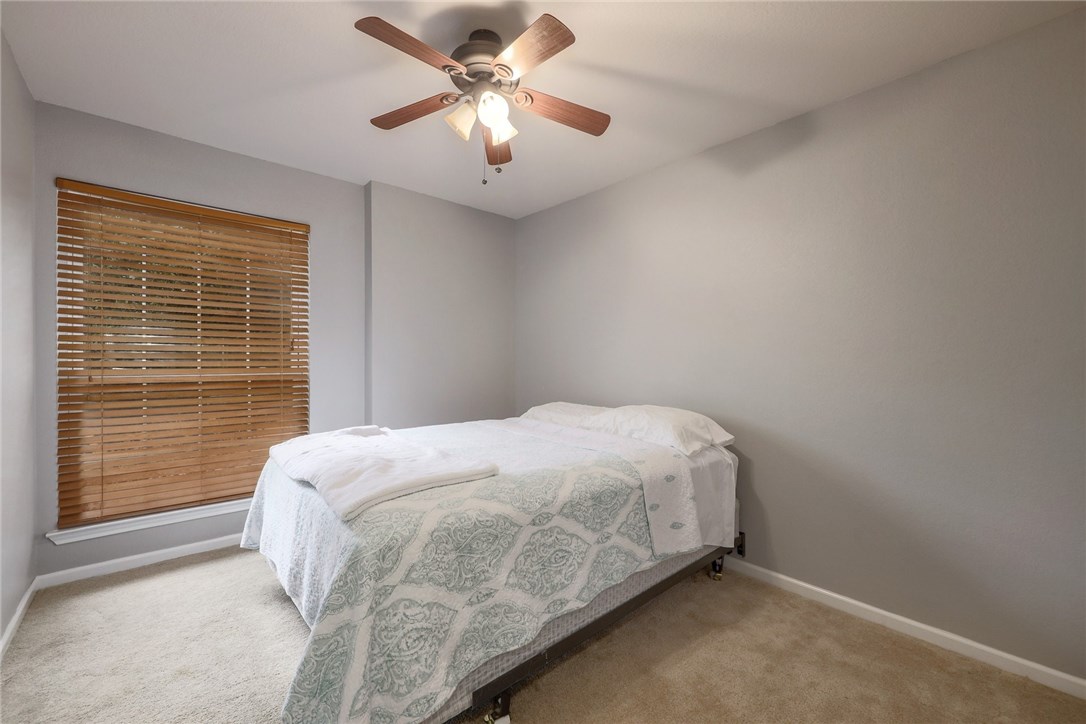 7908 Portland Trail Austin, TX 78729 - Photo 21 of 35 a bedroom with a bed and a ceiling fan