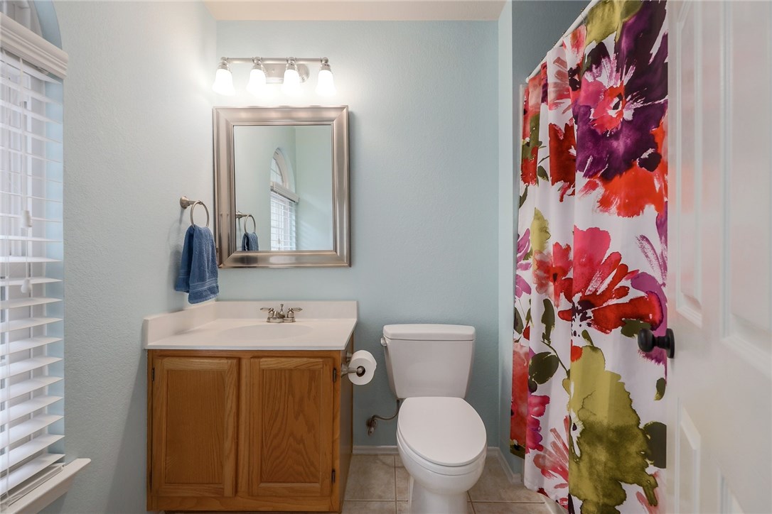 7908 Portland Trail Austin, TX 78729 - Photo 22 of 35 a bathroom with a toilet sink and mirror
