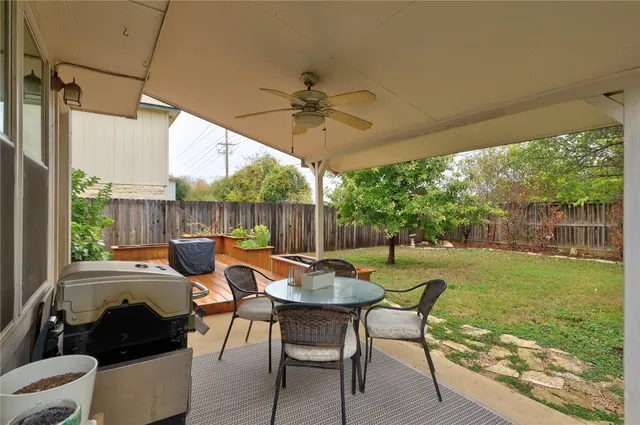 a view of a patio with a table chairs and a backyard