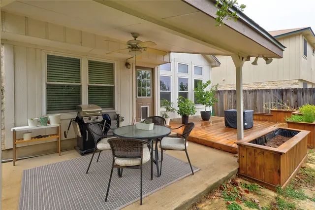 a view of a patio with table and chairs with wooden floor and fence