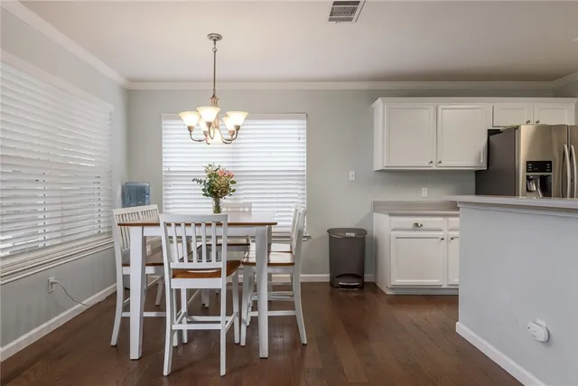 a dining room filled chandelier and kitchen view