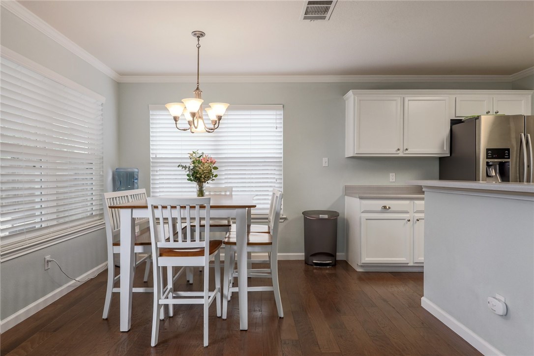 7908 Portland Trail Austin, TX 78729 - Photo 9 of 35 a dining room filled chandelier and kitchen view