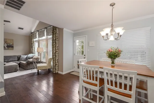 a living room with furniture a chandelier and wooden floor