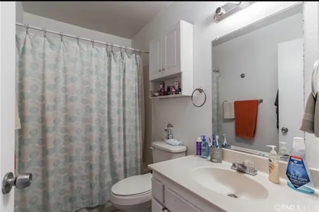 a bathroom with a sink a toilet and shower curtain