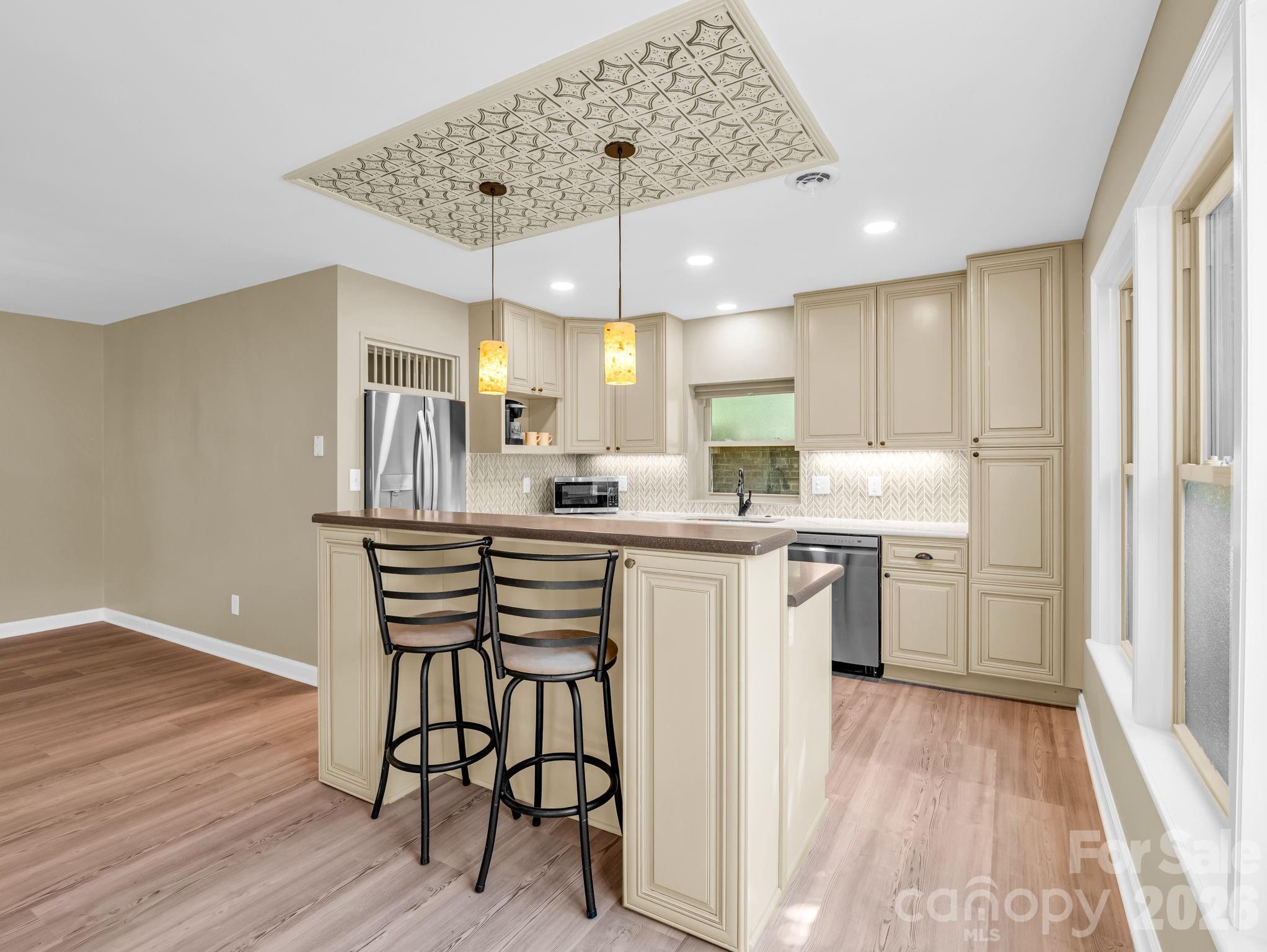 44 Jervey Road, Unit 4C Tryon, NC 28782 - Photo 7 of 35 a kitchen with a refrigerator a sink dishwasher a stove and white cabinets with wooden floor
