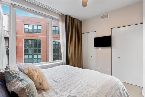 a bedroom with a bed and a flat tv screen in it