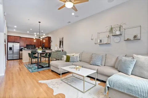 a living room with furniture kitchen view and a chandelier