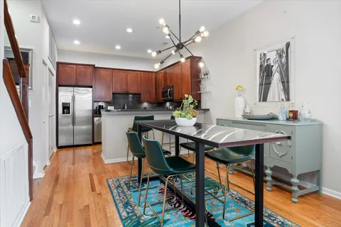 a kitchen with stainless steel appliances a table chairs refrigerator and microwave