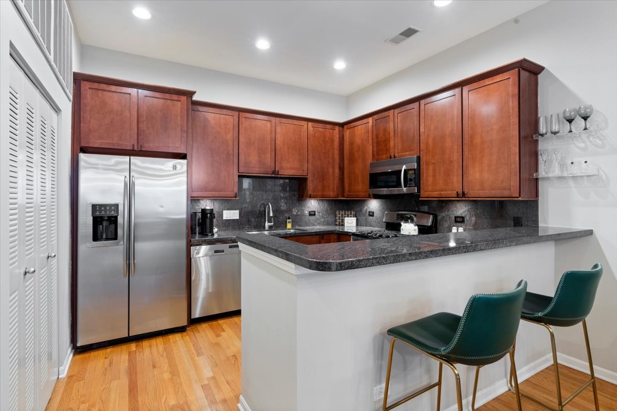 926 North Crosby Street Chicago, IL 60610 - Photo 8 of 19 a kitchen with stainless steel appliances granite countertop a refrigerator a stove a sink and a microwave