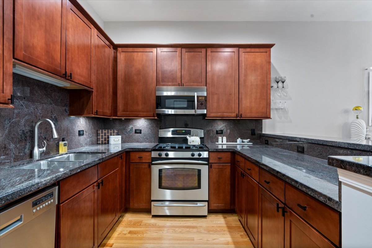 926 North Crosby Street Chicago, IL 60610 - Photo 9 of 19 a kitchen with granite countertop wooden cabinets and a stove top oven