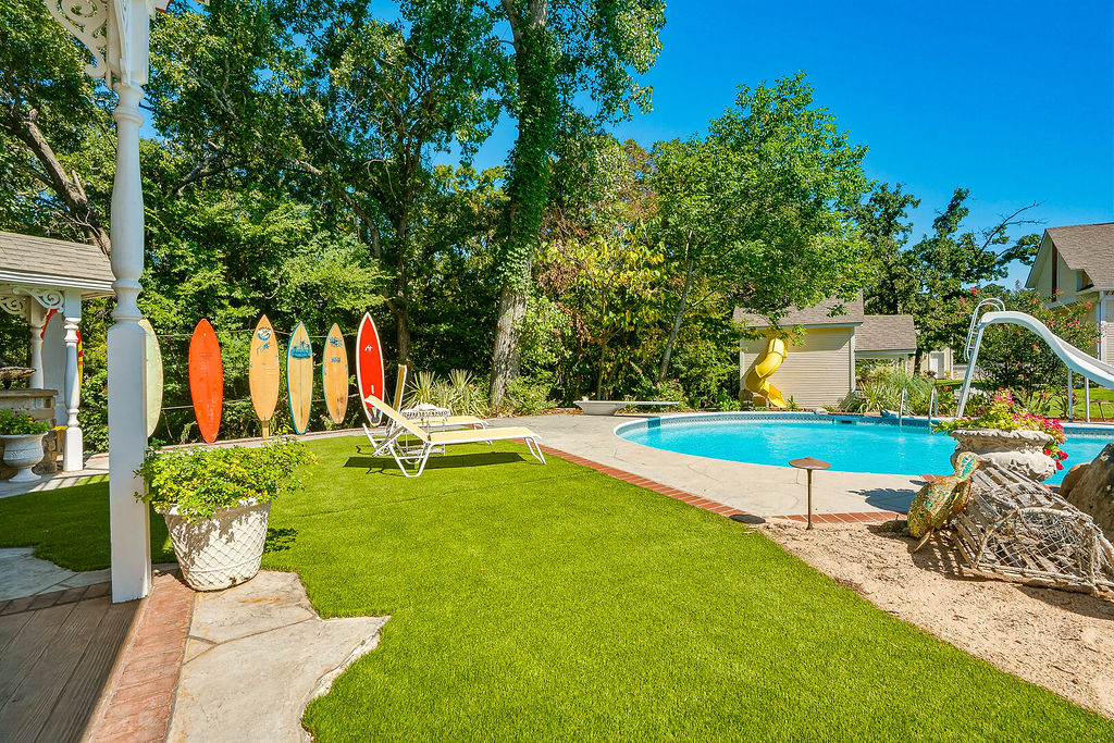1009 Southeast County Road Ada, OK 74820 - Photo 64 of 92 Swimming pool with a slide, artificial turf, and mature trees