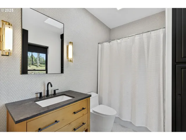 a bathroom with a sink a toilet and mirror