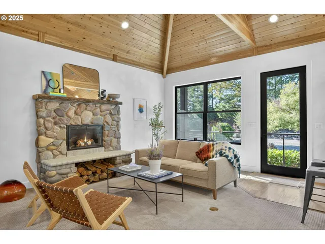 a living room with furniture a fireplace and a large window