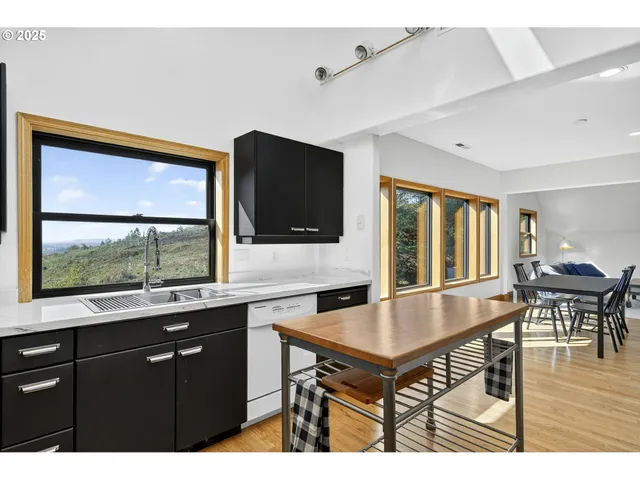 a kitchen with a table chairs refrigerator and sink