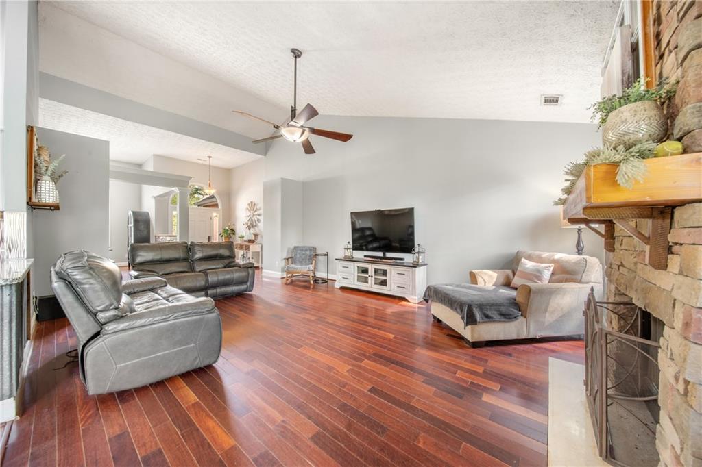 174 Foxtail Pass Acworth, GA 30101 - Photo 11 of 38 a living room with furniture a flat screen tv and a wooden floor