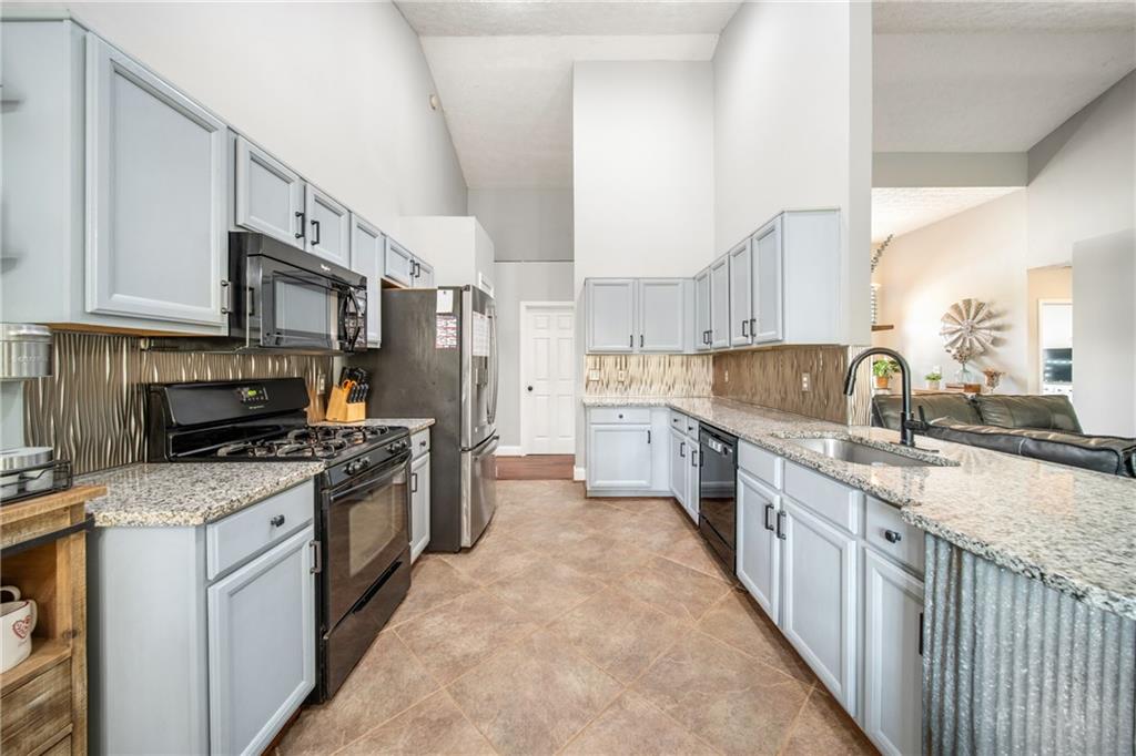 174 Foxtail Pass Acworth, GA 30101 - Photo 16 of 38 a kitchen with stainless steel appliances granite countertop a stove a sink dishwasher a refrigerator and a oven