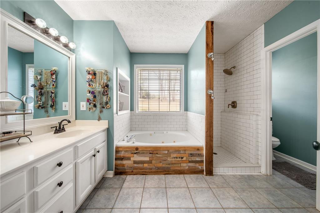 174 Foxtail Pass Acworth, GA 30101 - Photo 24 of 38 a bathroom with a tub sink and mirror