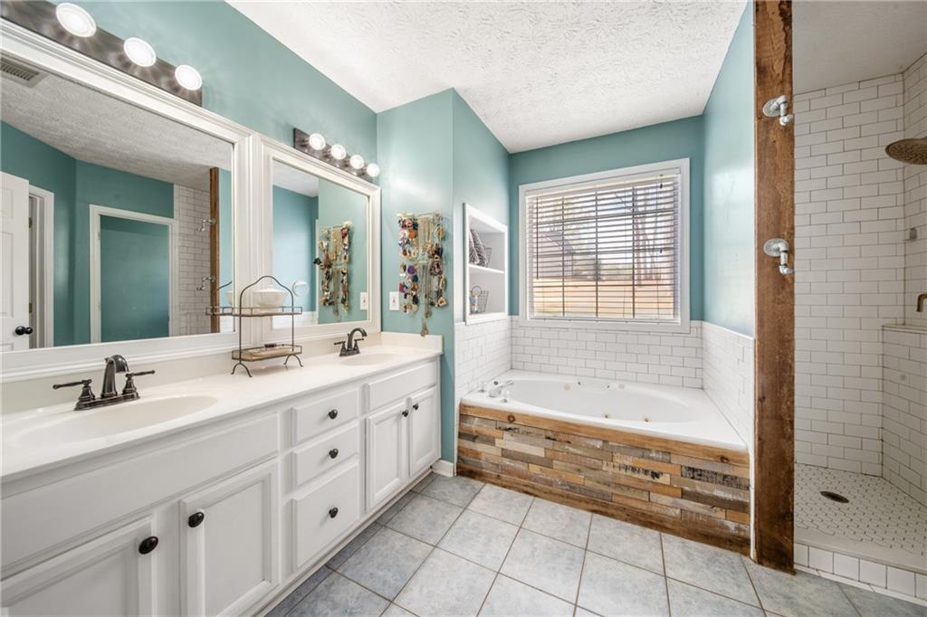 174 Foxtail Pass Acworth, GA 30101 - Photo 25 of 38 a bathroom with a tub sink and mirror