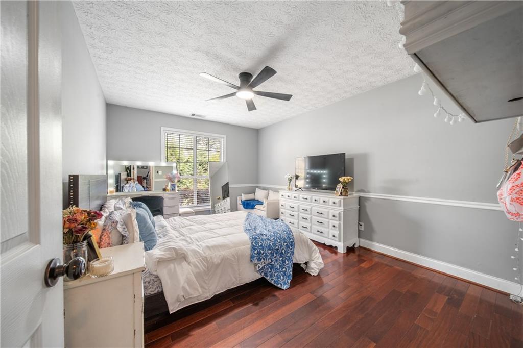 174 Foxtail Pass Acworth, GA 30101 - Photo 28 of 38 a bedroom with a bed a flat screen tv and a fireplace