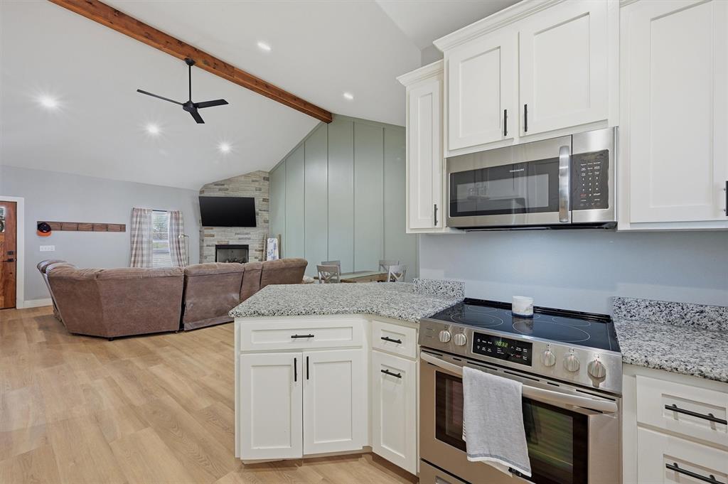 501 Bonham Street Tom Bean, TX 75491 - Photo 13 of 40 a kitchen with stainless steel appliances granite countertop a stove a microwave and a sink