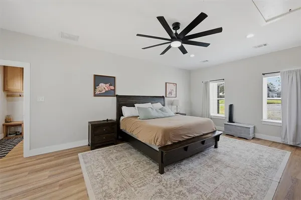 a bed sitting in a spacious bedroom next to a window