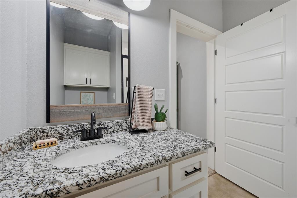 501 Bonham Street Tom Bean, TX 75491 - Photo 25 of 40 a bathroom with a granite countertop sink and a mirror