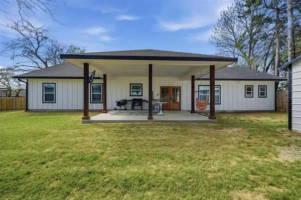a view of a house with a backyard patio and a tree