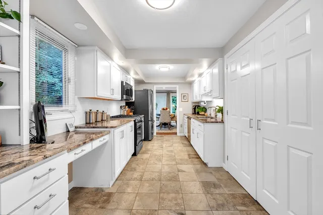 a large kitchen with kitchen island granite countertop a large counter top a sink stainless steel appliances and cabinets