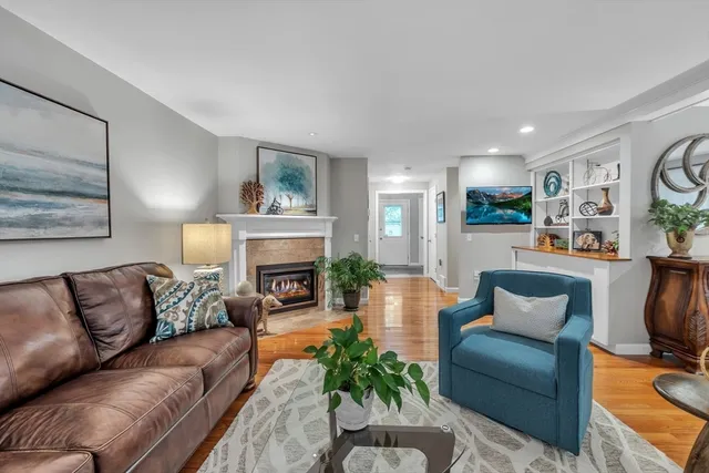 a living room with furniture fireplace and a large window