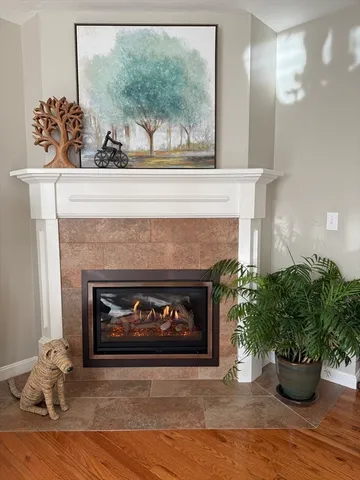 a living room with a fireplace and wooden floor