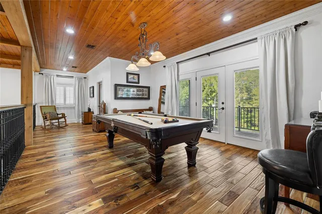 a living room with stainless steel appliances furniture a rug and a large window