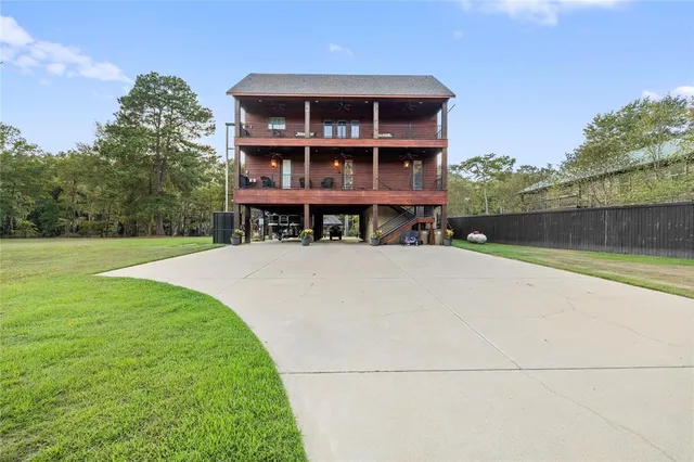 a view of house with outdoor space and large tree