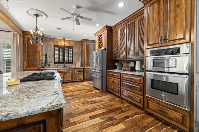 a kitchen with stainless steel appliances granite countertop a stove a sink and a refrigerator