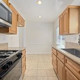 a kitchen with a sink stove top oven and cabinets