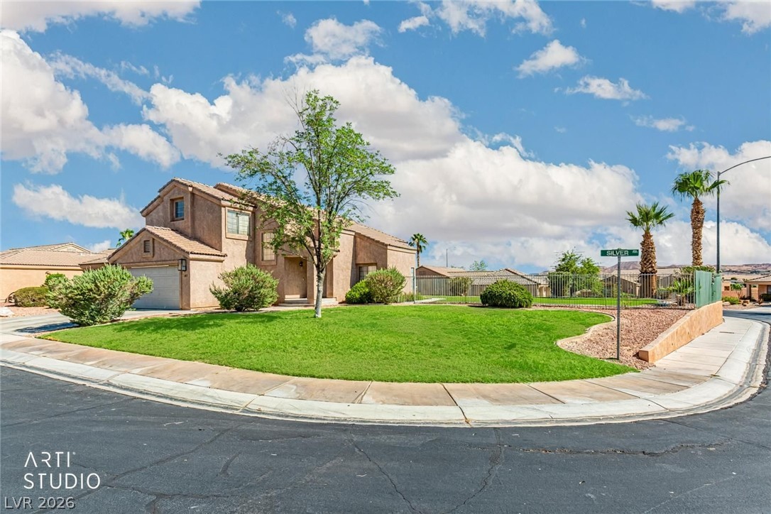 Manicured green lawns frame this stucco home occupying a prominent corner lot location.