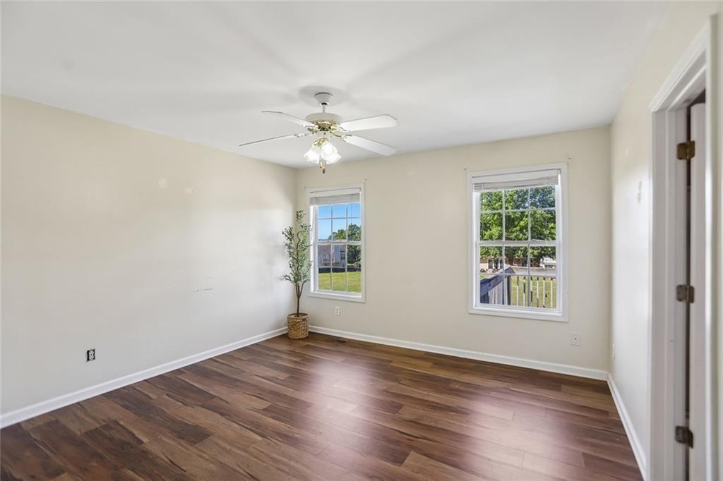 9720 Poole Road Villa Rica, GA 30180 - Photo 15 of 40 an empty room with wooden floor and windows