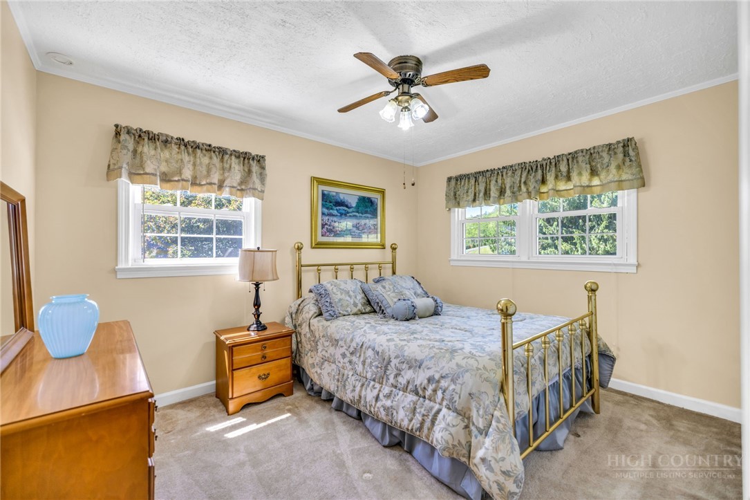 346 Piney Creek Road Lansing, NC 28643 - Photo 18 of 24 a bedroom with a bed a window and a chandelier