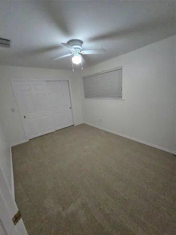 an empty room with a chandelier fan