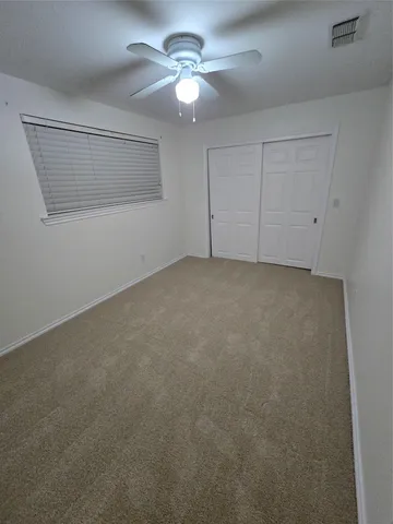 a view of a big room with chandelier fan and windows