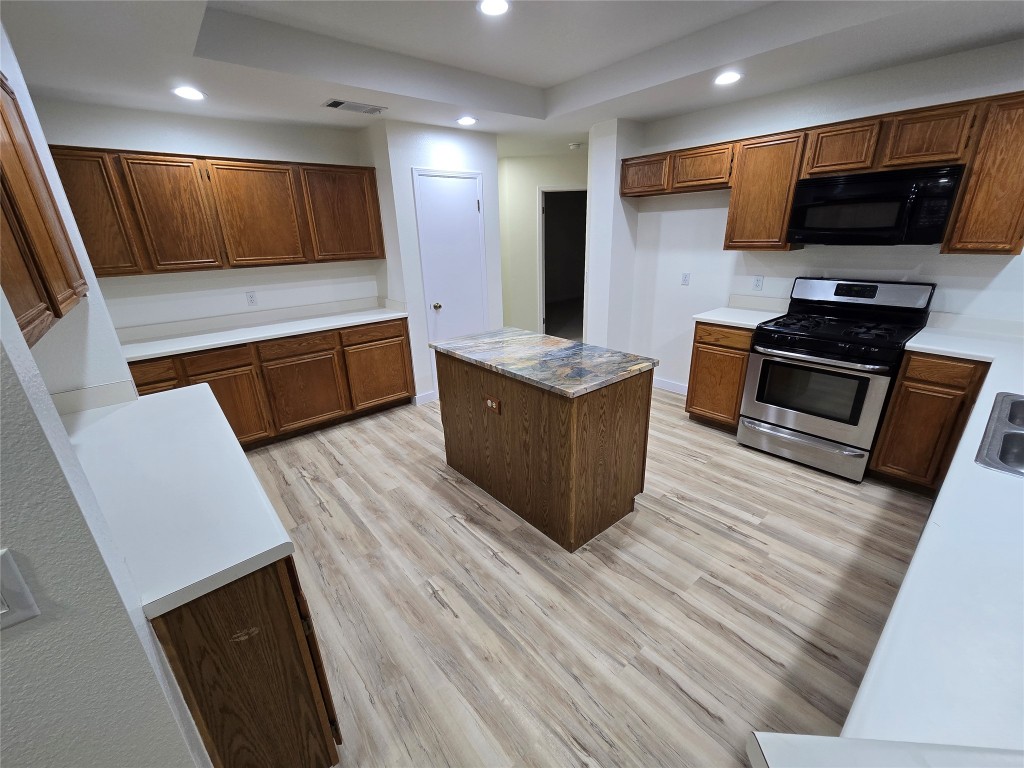8511 Ephraim Road Austin, TX 78717 - Photo 4 of 14 a kitchen with stainless steel appliances wooden cabinets and a stove top oven