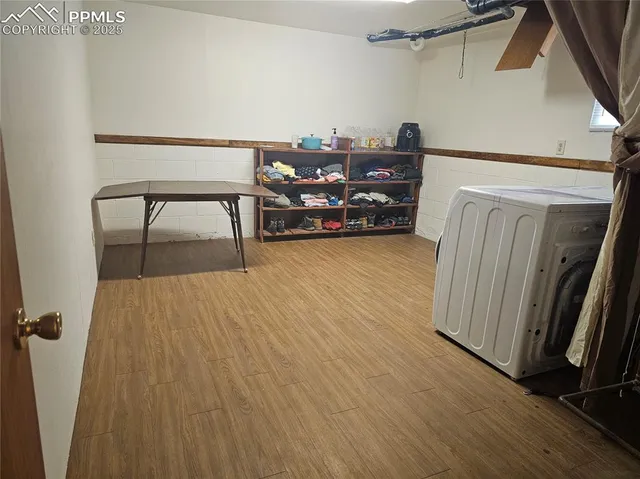 a view of empty room with wooden floor and fireplace