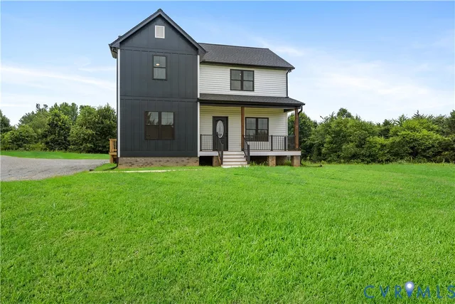 a view of a brick house with a big yard and large tree