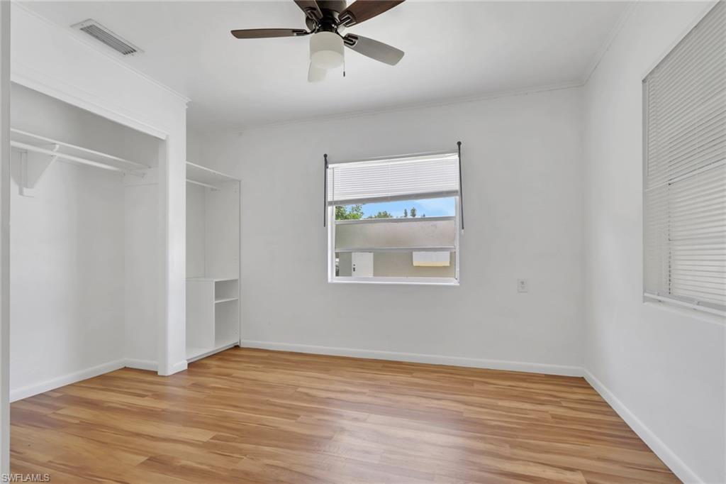 11360 Hunting Road Bonita Springs, FL 34135 - Photo 13 of 27 Bright room featuring wood-finish flooring, a ceiling fan with light fixture, and a window with blinds